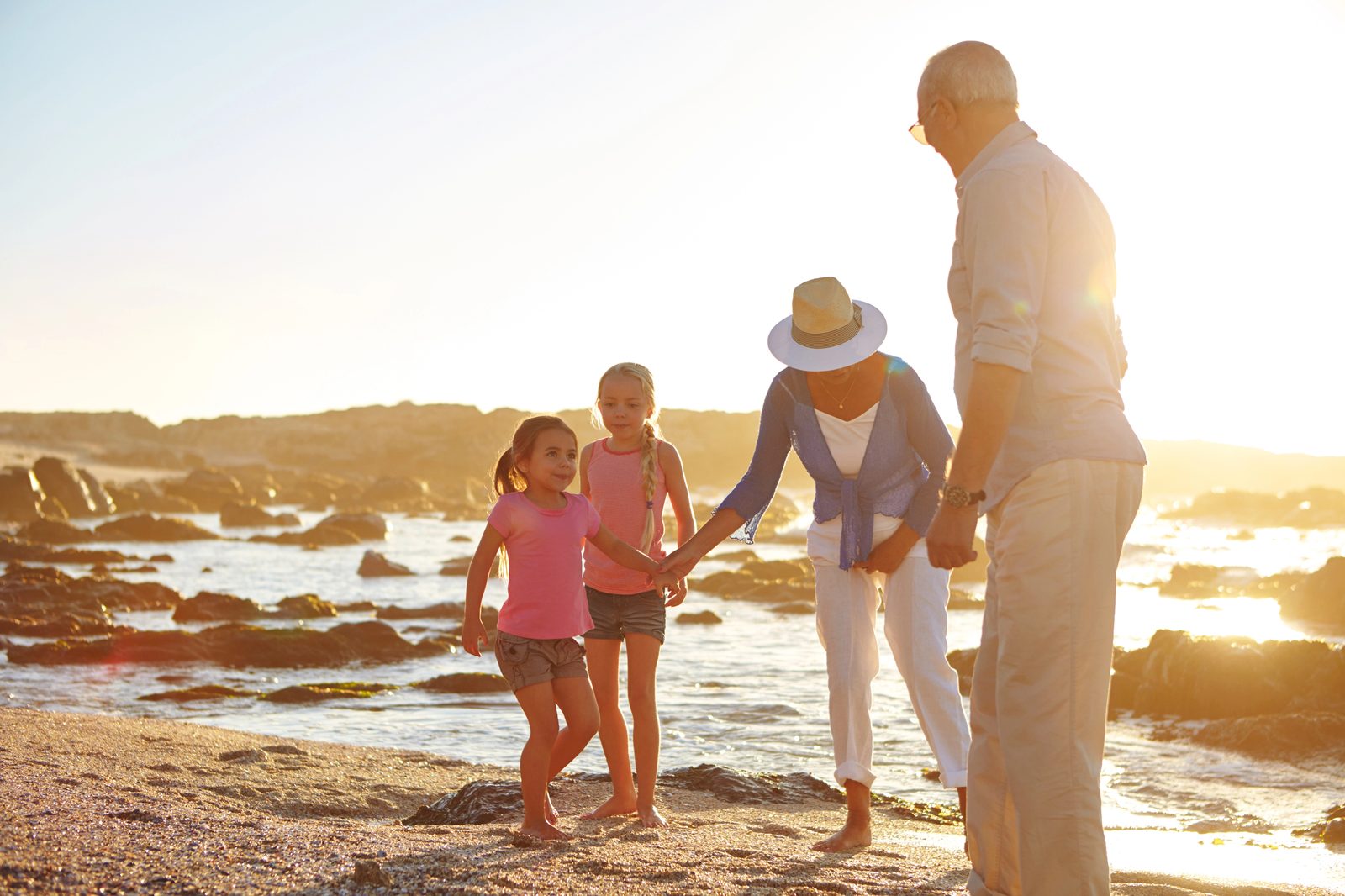 Grandparents and grandchildren together on the beach at sunset
